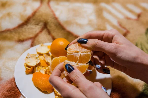 Das Mädchen putzt Mandarinen — Stockfoto