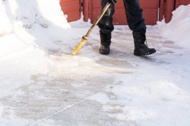 Kişi kar süpürge ile piyango.