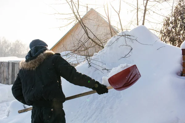 La persona lancia una pala rossa la neve . — Foto Stock