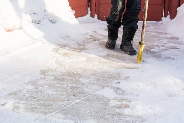 La personne balaie la neige avec le balai . — Photo