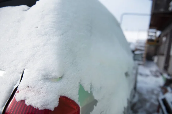 눈은 자동차 위에 놓여 있다. 눈이 내렸다. 자동차에 쌓인 눈을 가까이 서 본 것입니다. 차의 날개. — 스톡 사진