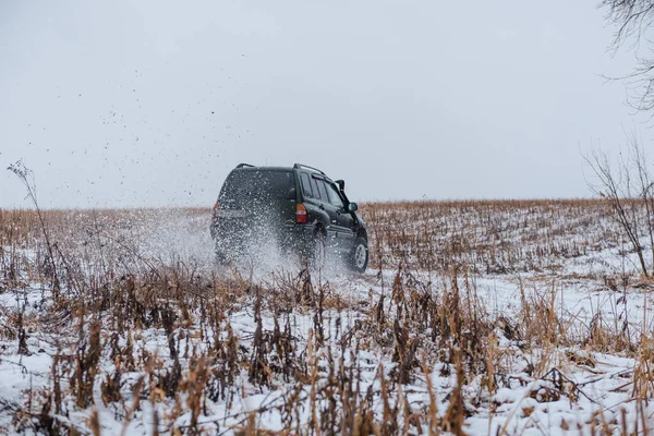 Condução off-road. em um jipe na primeira neve. carro na lama. dirigindo através da lama em um carro simples . — Fotografia de Stock