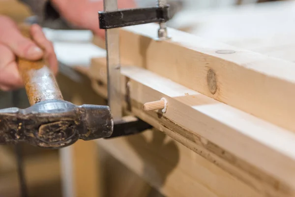 Tasselli martello su un albero. uomo tasselli martello in una superficie di legno . — Foto Stock