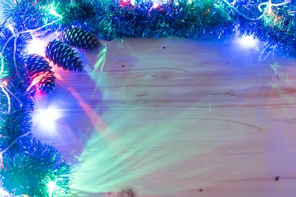 Fundo de Natal. A grinalda brilha sobre um fundo de madeira. luzes de Natal coloridas fundo — Fotografia de Stock