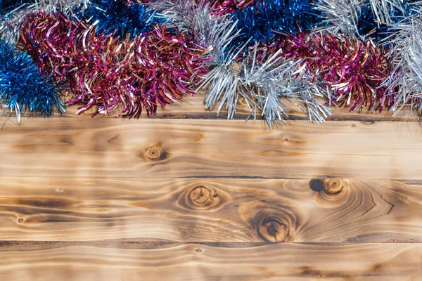 Sfondo natalizio. Braccialetto colorato su uno sfondo di legno . — Foto Stock