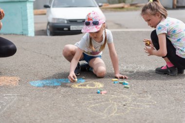 Zarinsk, Rusya - Haziran 01, 2019: Çocuklar kaldırıma resim çiziyor. Renkli tebeşirle çiz