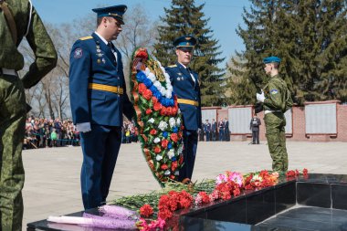 Zarinsk, Rusya - 9 Mayıs 2019: Zafer Günü 'nde insanlar çiçek bırakır. Çiçekleri 9 Mayıs 'ın ebedi ateşine seriyorum..