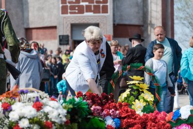 Zarinsk, Rusya - 9 Mayıs 2019: Zafer Günü 'nde insanlar çiçek bırakır. Çiçekleri 9 Mayıs 'ın ebedi ateşine seriyorum..