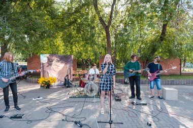 Zarinsk, Rusya - 19 Ağustos 2019: Gençler şarkı söyler. Parktaki meydanda şarkı söylemek. Sokaktaki rock konseri