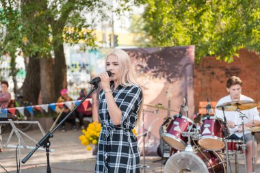 Zarinsk, Rusya - 19 Ağustos 2019: Gençler şarkı söyler. Parktaki meydanda şarkı söylemek. Sokaktaki rock konseri