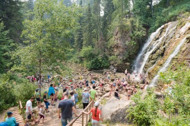 Zarinsk, Rusya - 20 Haziran 2019: Birçok insan bir şelalede yıkanır. Mağara şelalesindeki insanlar.