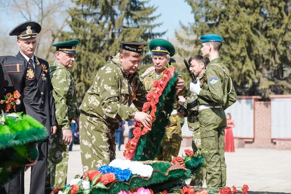 ロシアのザリンスク- 2019年5月9日:人々は勝利の日に花を咲かせます。5月9日の永遠の炎に花を咲かせる. — ストック写真