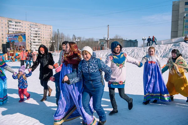 Zarinsk, Rusko - 15. dubna 2019: Mnoho lidí jezdí v zimě v ulicích na kole. Slovanské tance v zimě. — Stock fotografie