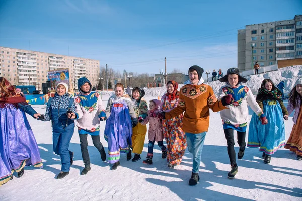 Zarinsk, Rusko - 15. dubna 2019: Mnoho lidí jezdí v zimě v ulicích na kole. Slovanské tance v zimě. — Stock fotografie