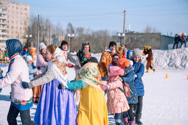 stock image Zarinsk, Russia - April 15, 2019: Many people drive a round dance in the street in winter. Slavic dances in the winter.