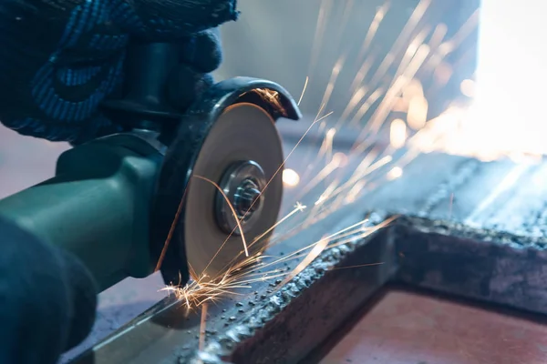 Metallo tagliato con una rettificatrice angolare. Sparks stanno volando. Strumento di costruzione smerigliatrice. Un uomo sta tagliando il metallo. Indossare guanti per la sicurezza . — Foto Stock