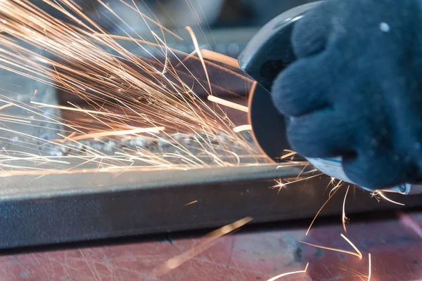 Metallo tagliato con una rettificatrice angolare. Sparks stanno volando. Strumento di costruzione smerigliatrice. Un uomo sta tagliando il metallo. Indossare guanti per la sicurezza . — Foto Stock