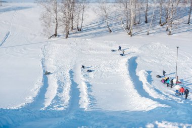 Birçok insan tubenge biner. Kışın dağdan kayak yapmak. kış eğlencesi