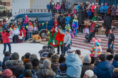 Zarinsk, Rusya-26 Şubat 2017: Rusya 'daki Maslenitsa' da sokak şenlikleri. Kış tatilinde bir sürü insan. Ödül için bir direğe tırmanan şenlikler