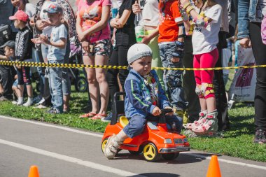 Zarinsk, Rusya-Haziran 3, 2017: küçük çocuklar bisiklete biniyor. Çocuklar mobiletlere ve çocuk arabalarına biniyor. Yazın sokakta çocuk tatili. Çocuklar gülümsüyor..