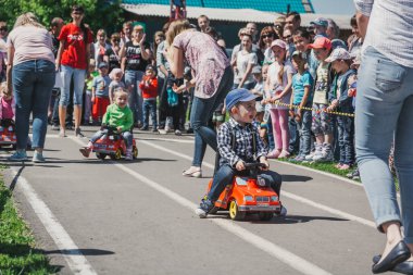 Zarinsk, Rusya-Haziran 3, 2017: küçük çocuklar bisiklete biniyor. Çocuklar mobiletlere ve çocuk arabalarına biniyor. Yazın sokakta çocuk tatili. Çocuklar gülümsüyor..