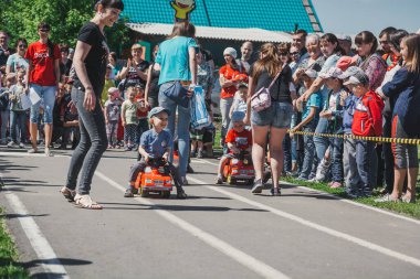 Zarinsk, Rusya-Haziran 3, 2017: küçük çocuklar bisiklete biniyor. Çocuklar mobiletlere ve çocuk arabalarına biniyor. Yazın sokakta çocuk tatili. Çocuklar gülümsüyor..