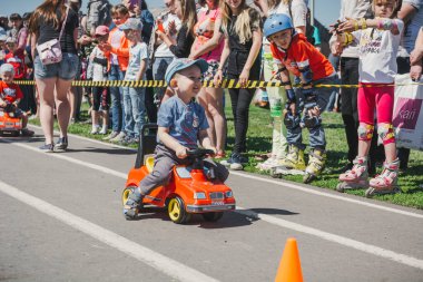 Zarinsk, Rusya-Haziran 3, 2017: küçük çocuklar bisiklete biniyor. Çocuklar mobiletlere ve çocuk arabalarına biniyor. Yazın sokakta çocuk tatili. Çocuklar gülümsüyor..