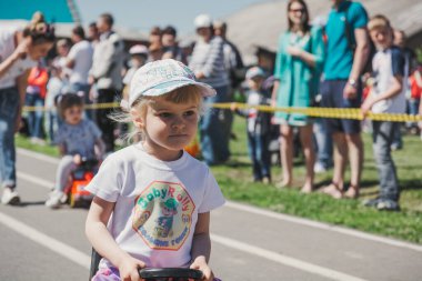 Zarinsk, Rusya-Haziran 3, 2017: küçük çocuklar bisiklete biniyor. Çocuklar mobiletlere ve çocuk arabalarına biniyor. Yazın sokakta çocuk tatili. Çocuklar gülümsüyor..
