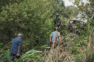Zarinsk, Rusya-16 Ağustos 2017: arabalar çamurun içinden geçiyor. Arabalar bataklıktan ve ormandan geçer. Erkekler arabaları itiyor. Arabalarda yarışmalar.