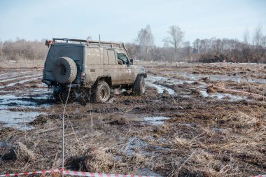 Zarinsk, Rusya -15 Nisan 2017: arabalar baharda çamurun içinden geçer. Arabalar bataklıktan geçer. Erkekler arabaları itiyor. Arabalarda yarışmalar.