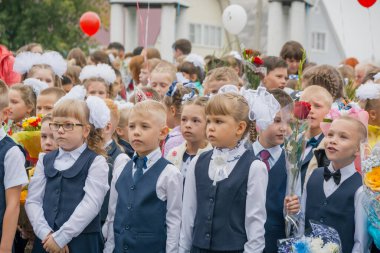 Zarinsk, Rusya-Eylül 01, 2017, bilgi günü, 1 Eylül, öğrenciler okulun önünde elinde çiçeklerle dikiliyor, çocuklar tüm sınıf tarafından bir hükümdarın üzerine inşa ediliyor. Okul üniformalı öğrenciler..