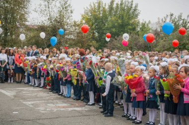 Zarinsk, Rusya-Eylül 01, 2017, bilgi günü, 1 Eylül, öğrenciler okulun önünde elinde çiçeklerle dikiliyor, çocuklar tüm sınıf tarafından bir hükümdarın üzerine inşa ediliyor. Okul üniformalı öğrenciler..