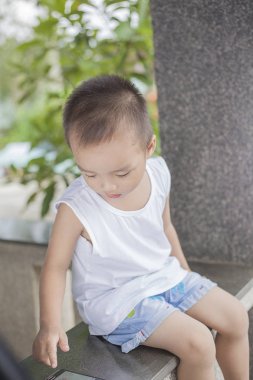 Cep telefonunuzun ekran dokunaklı verandada oturup bir çocuk