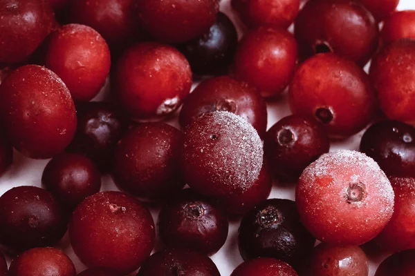 Many Frozen cranberry with hoarfrost in the pink background Stock Photo