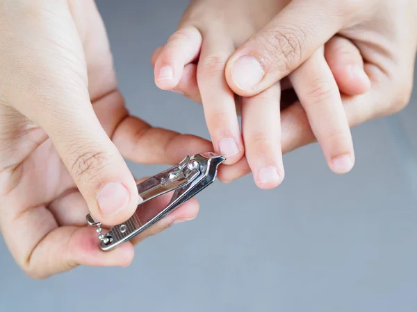 Actividad familiar madre uñas cortadas a mano para niños mediante el uso de cortauñas — Foto de Stock