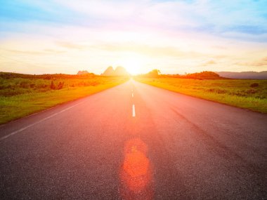 asfalt yol ile sarı mavi gökyüzü arka plan ve Lens Flare ya da gün batımı sırasında güneş lekesi