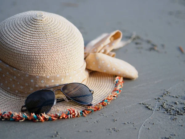 soyut seyahat şapka ve siyah sahilde koymak sunglass