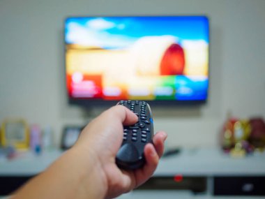 Tv uzaktan kumanda bir televizyon ile arka planda tutan el kadar kapatın.