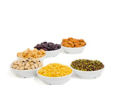 Badem, kaju fıstığı, sarı fasulye, yeşil fasulye, pirinç, fettucine, küçük beyaz fincan ve beyaz arka plan üzerinde tüm koymak