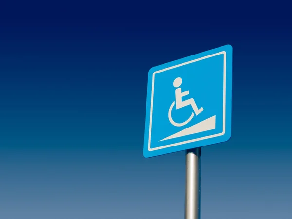 Parcheggio per disabili e segnaletica per sedie a rotelle e simboli su un palo di avvertimento automobilisti — Foto Stock