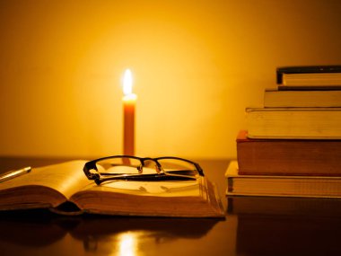 yığın eski bir ahşap masa ışıklı mum ve gözlük kitap lime lime