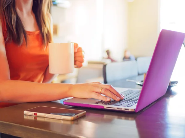 Досить молода жінка використовує ноутбук. Жінка працює на ноутбуці у відкритому кафе . — стокове фото