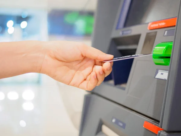 Крупный план женской руки, вставляющей дебетовую карту в банкомат. Горизонтальный выстрел . — стоковое фото