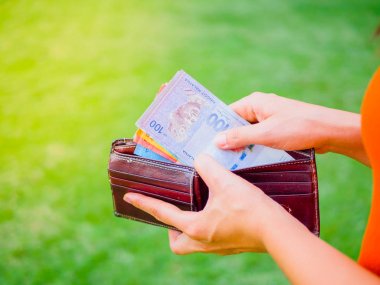Kadınların elleri yeşil çim sahada cüzdanından para yaptırmayı
