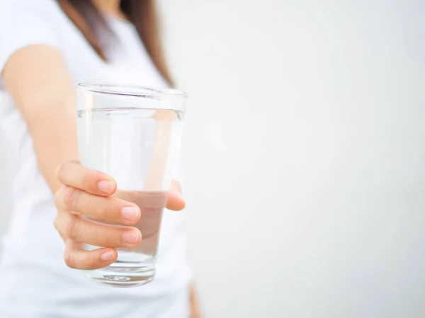 Een glas schoon mineraalwater in handen van de vrouw. — Stockfoto