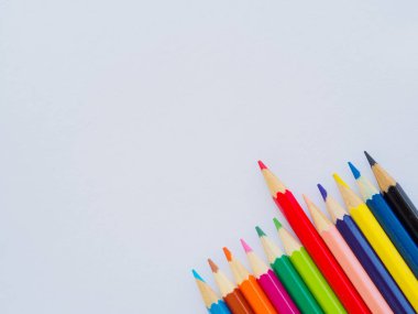 Beyaz kağıt üzerine renkli kalemler. Eğitim malzeme geri için okula, arka plan ve duvar kağıdı.