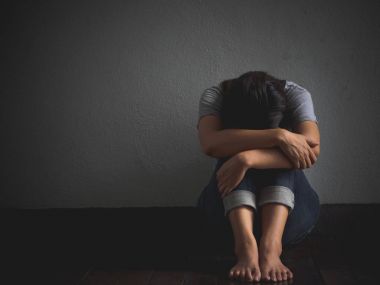 üzgün kadın kucakla onu diz ve çığlık. Boş bir odada tek başına oturan üzgün kadın.