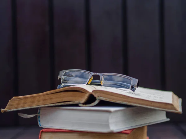Glasses put on Stack of books with wooden blackground — Stock Photo, Image