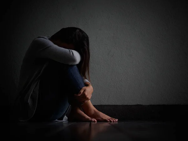 Mulher triste abraçar o joelho e chorar. Mulher triste sentada sozinha em um quarto vazio . — Fotografia de Stock