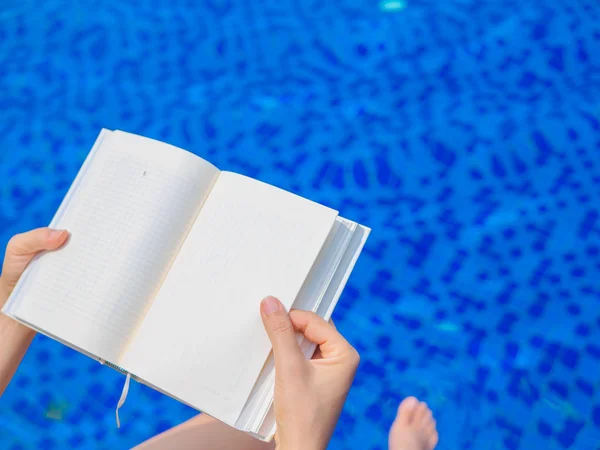 Donna lettura e relax vicino alla piscina di lusso — Foto Stock